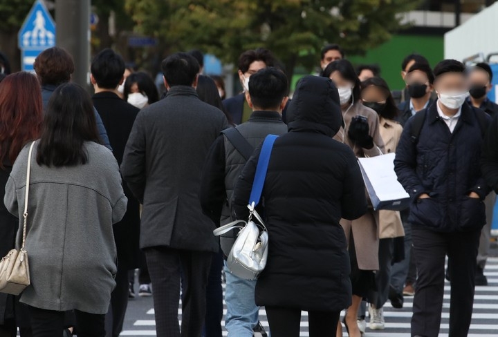 서울 아침 기온이 4도를 기록한 지난 18일 오전 서울 종로구 광화문 네거리 인근에서 두꺼운 옷을 입은 시민들이 횡단보도를 건너고 있다.