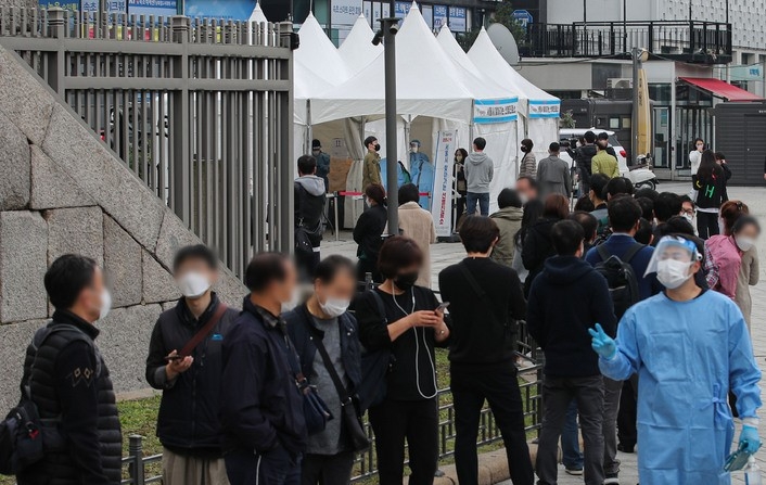 지난 19일 오전 서울 종로구 흥인지문 인근에 설치된 찾아가는 선별진료소에서 시장 종사자들이 검사를 받기 위해 대기하고 있다.