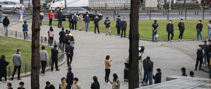 동대문종합시장 관련 확진자가 80명으로 집계된 19일 오전 서울 종로구 흥인지문 인근에 설치된 찾아가는 선별진료소에서 시장 종사자들이 검사를 받기 위해 대기하고 있다.