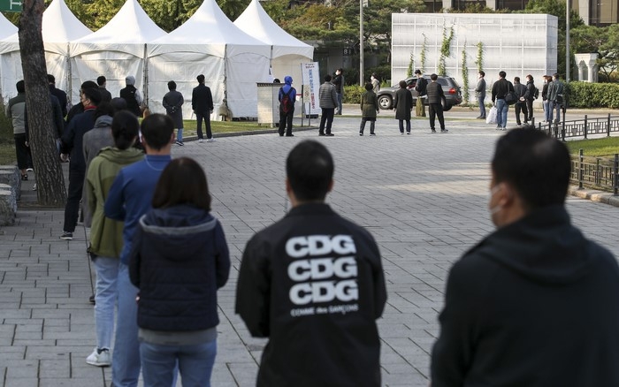 지난 21일 오전 서울 종로구 흥인지문 인근에 설치된 서울시 찾아가는 선별진료소를 찾은 시민들이 검사를 받기 위해 줄 서 있다.