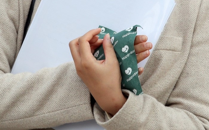 지난 21일 오전 서울 종로구 광화문 네거리에서 출근길 시민이 핫팩을 들고 있다.