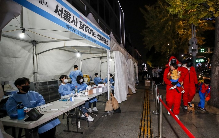 핼러윈 데이인 지난달 31일 오후 서울 용산구 이태원역 인근에 설치된 찾아가는 선별진료소 앞으로 할로윈 분장을 한 시민들이 지나가고 있다.