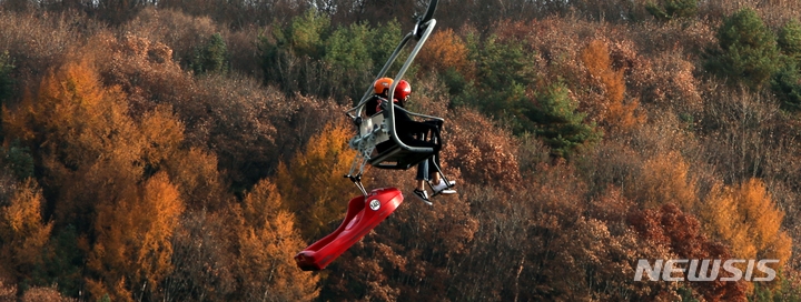 쾌청한 가을 하늘을 보인 6일 오후 가족 단위 나들이객들이 강원도 평창군 봉평면 휘닉스 평창 리조트에서 루지 체험 장비를 매단 리프틑 타고 있다.