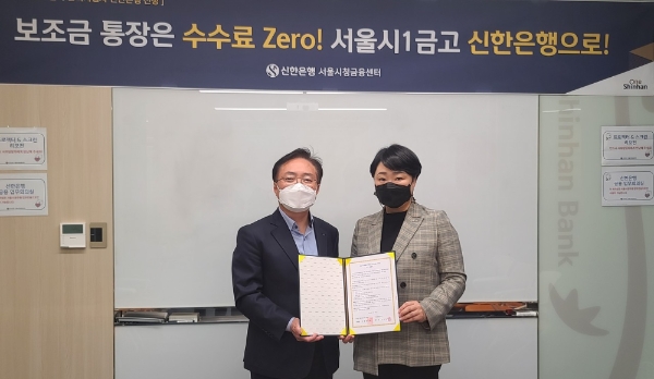 서울시청년활동지원센터와 신한은행이 업무협약을 체결하고 협약서를 펼쳐보이고 있다.