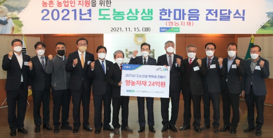 이성희 농협중앙회장(사진 왼쪽에서 일곱번째)이 15일 강원 춘천시에 위치한 농협 강원지역본부에서 도시와 농촌 농축협 조합장이 참석한 가운데 농촌지역 농업인을 위해 영농자재를 지원하는 '2021년 도농상생 한마음 전달식'을 개최하고 기념촬영을 하고 있다. 사진/ = 농협 제공