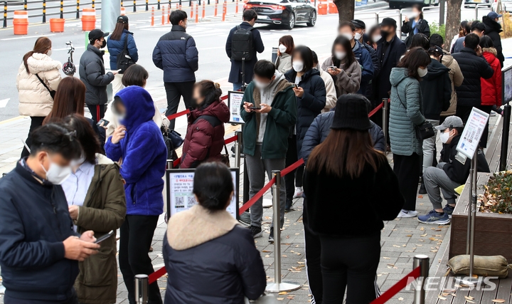 지난 18일 오전 서울 송파구보건소에 설치된 코로나19 선별진료소를 찾은 시민들이 검사를 받기 위해 대기하고 있다.