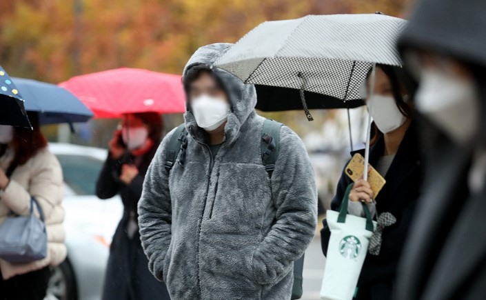 초겨울 추위를 보이는 9일 오전 서울 종로구 광화문 네거리에서 시민들이 따뜻한 옷을 입고 있다.
