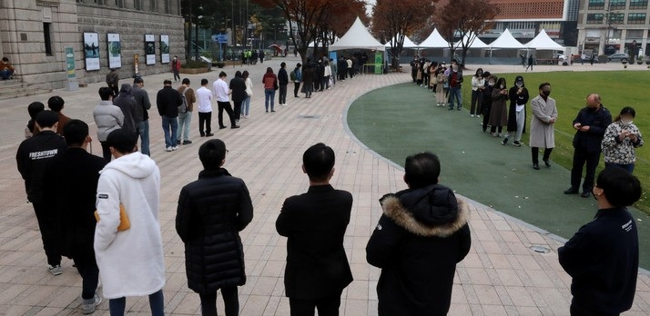 지난 21일 오후 서울 중구 서울광장 임시선별검사소에서 시민들이 코로나19 검사를 받기 위해 길게 줄 지어 서 있다.