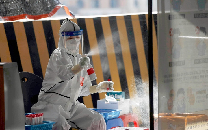 지난 22일 광주 북구 용봉동 선별진료소에서 보건소 의료진이 코로나19 검체를 채취한 직후 소독하고 있다. 최근 광주에선 학교, 목용탕 등지에서 확진자가 폭증하고 있다. (사진=광주 북구 제공)