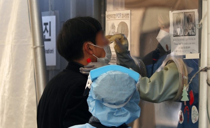 코로나19 신규 확진자가 4,116명으로 집계된 24일 오전 서울 용산역 전면광장에 설치된 임시선별진료소에서 의료진이 검체를 채취하고 있다.