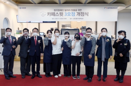 25일 서울 중구 소재 카페스윗 3호점 개점식에서 신한은행 진옥동 은행장(왼쪽 세번째)과 국립서울농학교 김은숙 교장(오른쪽 두번째), 사회적협동조합 스윗 이정자 이사(오른쪽 첫번째) 및 카페스윗 3호점 직원들이 ‘카페’를 수어로 표현하고 있는 모습./ 사진 제공 = 신한은행