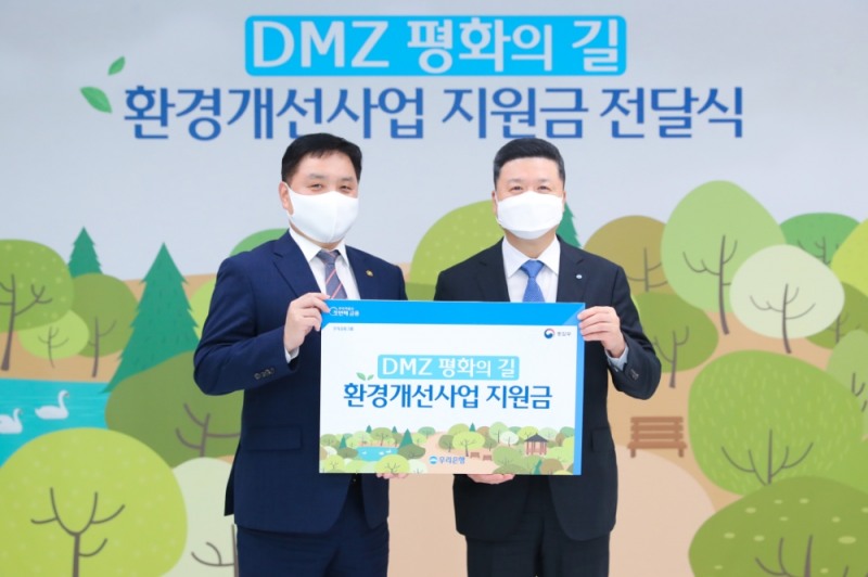 우리은행은 지난 25일 서울 중구 소재 우리은행 본점에서 통일부와 ‘DMZ 평화의 길’ 환경개선사업지원금 전달식을 가졌다. 권광석(오른쪽) 우리은행장과 최영준 통일부 차관이 기념촬영을 하고 있다. (사진=우리은행 제공)
