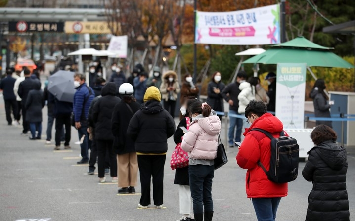 코로나19 신규 확진자가 3,901명으로 집계된 26일 오후 서울 서초구 고속터미널역 임시선별검사소에서 시민들이 검사를 받기 위해 줄을 서고 있다.