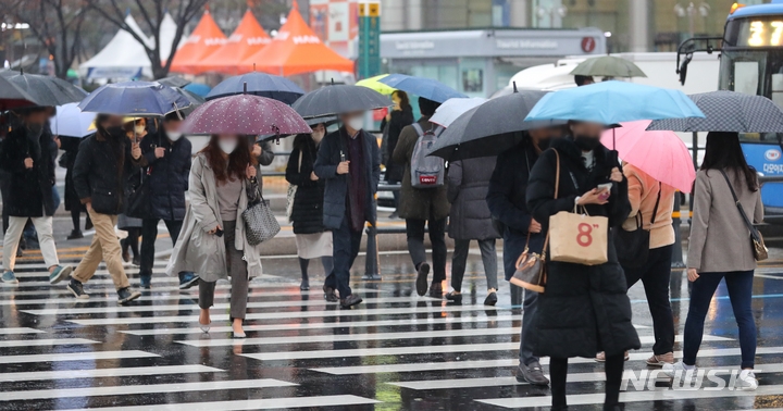 전국에 겨울비가 내린 지난달 30일 오전 세종대로 사거리에서 우산을 든 시민들이 출근길 발걸음을 옮기고 있다. 
