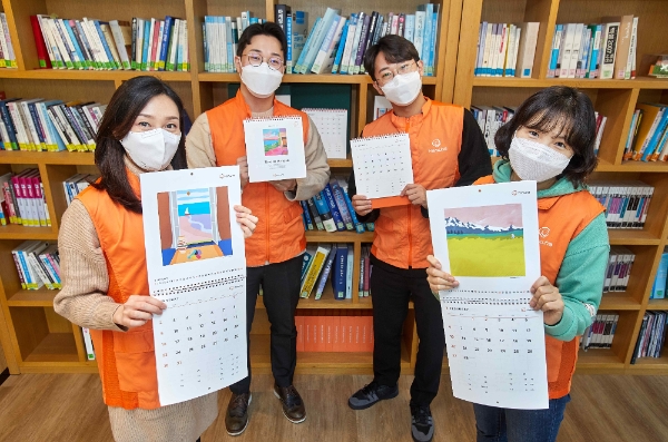 점자달력 제작 21주년을 맞아 한화봉사단 임직원들이 점자달력을 소개하며 기념촬영 하고 있다.