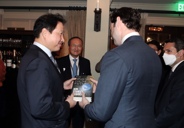 최태원 SK회장이 6일 미국 워싱턴D.C. 인근에서 열린 '2021 트랜스 퍼시픽 다이얼로그'에서 존 오소프 상원의원(조지아주)에게 책을 선물받으며 환담을 나누고 있다.(사진=SK)