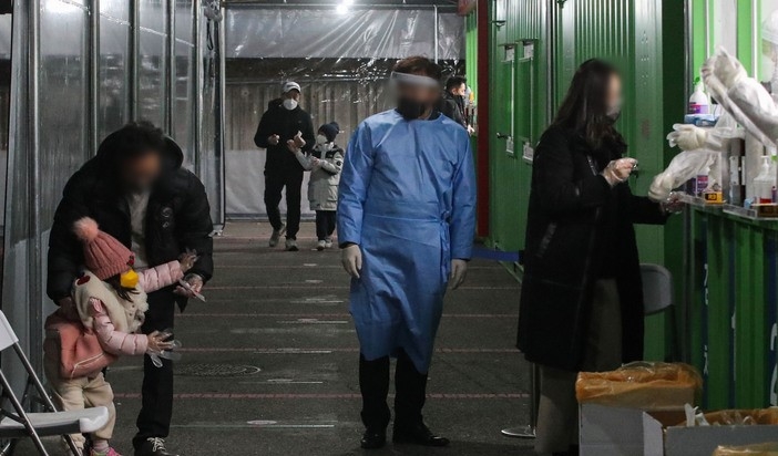 코로나19 신규 확진자가 5,817명으로 집계된 13일 밤 서울 송파구잠실종합운동장 제2주차장에 설치된 서울시 코로나19 검사소에서 한 아이가 검사를 피하고 있다.