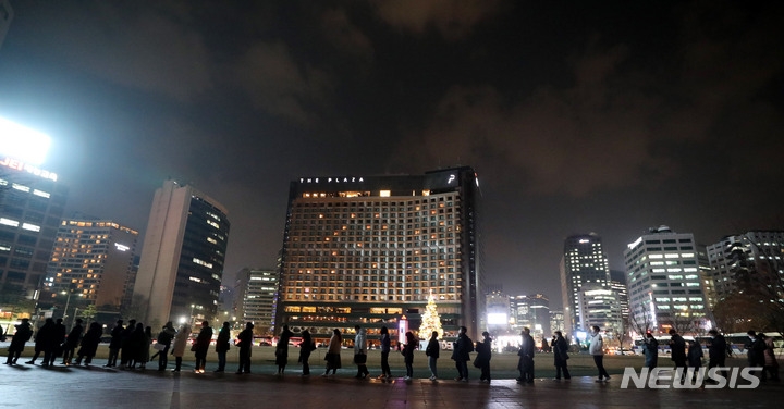 지난 20일 오후 서울 중구 서울광장 임시선별검사소에서 코로나19 검사를 받으려는 시민들이 밤 늦은 시간까지 길게 줄 서 있다.