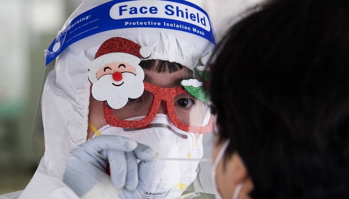 지난 24일 오전 대구 중구 국채보상운동기념공원 코로나19 임시선별검사소에서 의료진이 크리스마스 장식이 된 안경을 착용하고 검체 채취를 하고 있다.