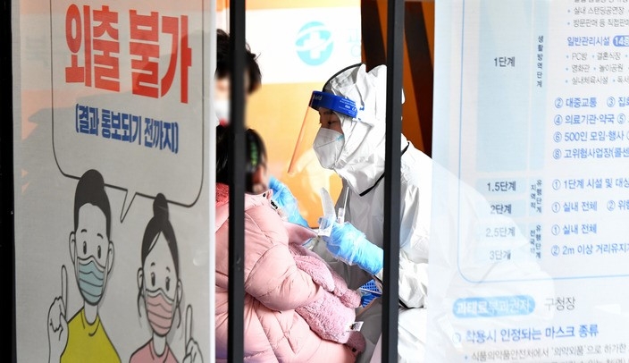 지난 23일 오후 광주 북구선별진료소에서 한 어린이가 코로나19 검체를 채취하고 있다.