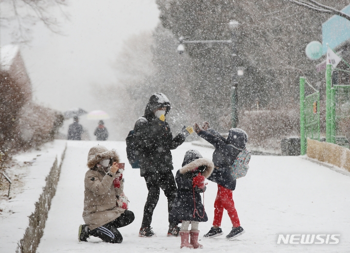 올 겨울 첫 대설주의보가 발령된 18일 오후 서울 서대문구에서 어린이들이 엄마아빠와 즐거운 시간을 보내고 있다.
