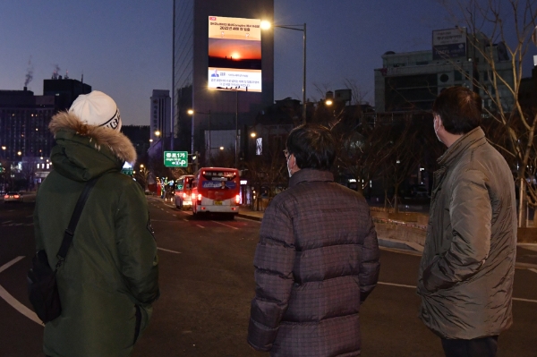 시민들이 광화문 인근 대형 전광판에 송출된 SK이노베이션 일출 생중계 화면을 통해 임인년 첫 해돋이를 감상하고 있다.