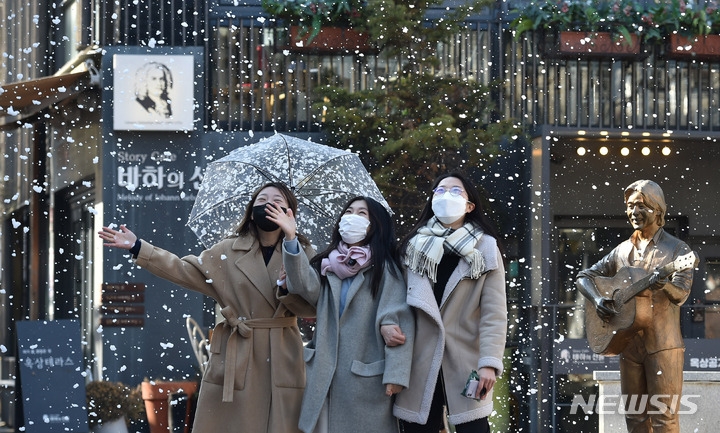 13일 오전 대구 중구 ‘김광석 다시 그리기 길’에 인공 눈이 내리고 있다. 야외 콘서트홀 출입구 옆 벽화에 서면 30초가량 인공 눈이 내리며 2월 초까지 운영된다.