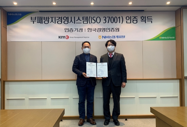NH농협캐피탈은 21일, 공인인증기관인 한국경영인증원(KMR)으로부터 여전업계 최초로 부패방지경영시스템(ISO37001) 인증을 획득했다고 밝혔다. 박태선 NH농협캐피탈 대표이사(왼쪽)와 이영찬 한국경영인증원 상무(오른쪽)가 수여식 후 기념촬영을 하고 있다.