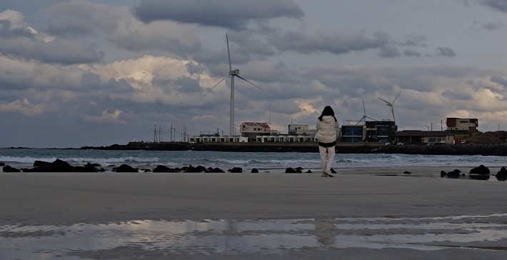 21일 오후 제주시 구좌읍 월정리에서 여행객이 겨울 바다를 즐기고 있다.