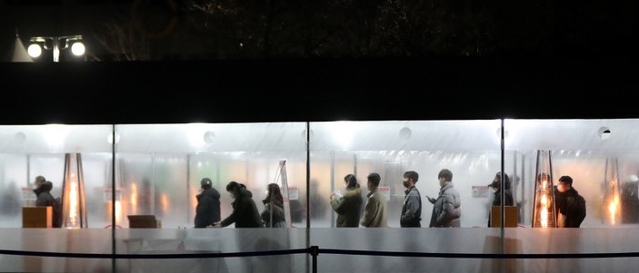코로나19의 신규 확진자가 급속한 확산세를 보인 24일 오후 서울 송파구 잠실종합운동장 제2주차장 임시선별검사소에서 밤 늦은 시간에도 코로나19 검사를 받으려는 시민들이 길게 줄지어 서 있다.