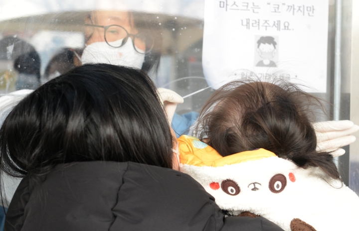 코로나19 신규 확진자 수가 13,012명으로 최다를 기록한 26일 울산 남구보건소 임시선별검사소에서 한 어린이가 코로나19 검사를 받고 있다.