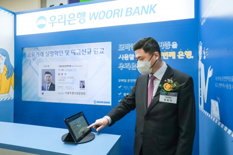 권광석 우리은행장이 지난 27일 마포구 소재 서울서부면허시험장에서 열린 모바일 운전면허증 개통식 행사에 참석해 실명확인 서비스를 시연하고 있다. (사진=우리은행 제공)