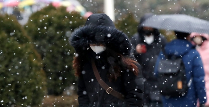 출근길 눈이 내린 지난 19일 오전 서울 도심에서 시민들이 눈을 맞으며 발걸음을 재촉하고 있다.