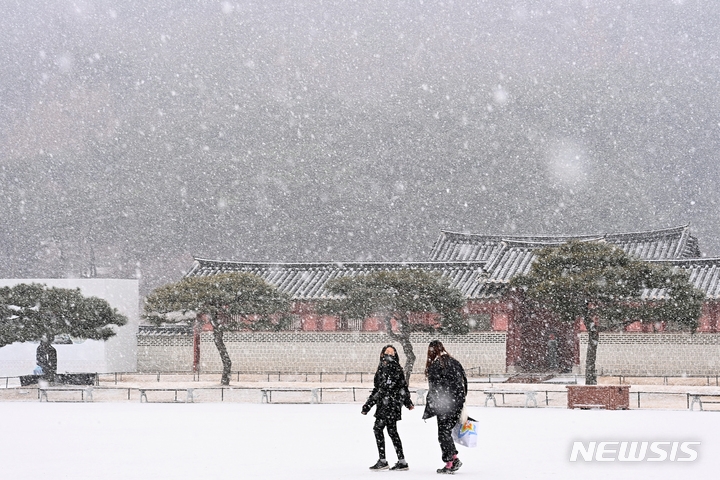 수도권지역에 대설주위보가 내려진 지난달 19일 오후 경기도 수원시 팔달구 화성행궁에서 시민들이 함박눈을 맞으며 걸어가고 있다.