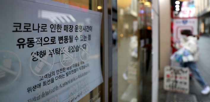 정부가 코로나19 확산세에도 사회적 거리두기 등 방역조치 완화 가능성을 내비치고 있다. 지난 11일 오후 서울 중구 명동 한 점포에 '코로나로 인한 매장 운영시간이 유동적으로 변동될 수 있는 점 양해 부탁드리겠습니다'라는 문구가 부착돼 있다.