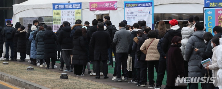 코로나19 신규 확진자수가 닷새째 5만명대를 기록한 14일 오전 서울 송파구 선별진료소에서 시민들이 코로나19 검사를 받기 위해 길게 줄지어 서 있다.