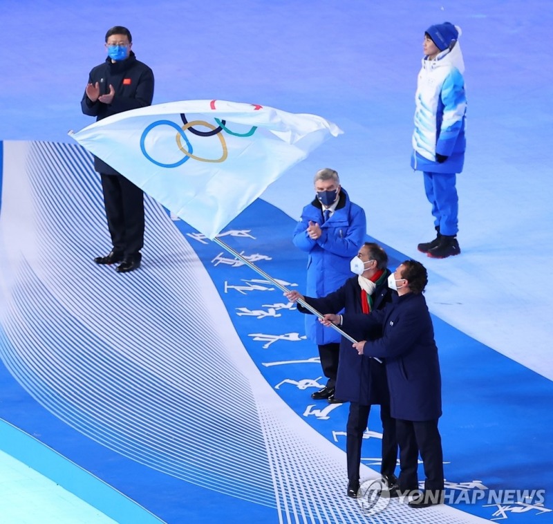 (베이징=연합뉴스) 20일 중국 베이징 국립경기장에서 열린 2022 베이징 동계올림픽 폐회식에서 토마스 바흐 국제올림픽위원회(IOC) 위원장에게 대회기를 넘겨받은 2026 동계올림픽 개최지 이탈리아 주세파 살라 밀라노 시장과 지안피에트로 게디나 코르티나담페초 시장이 흔들고 있다.