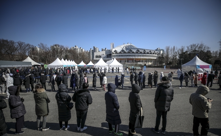 지난 20일 오후 서울 송파구 잠실종합운동장 제2주차장 임시선별검사소를 찾은 시민들이 검사를 위해 줄 서 있다.
