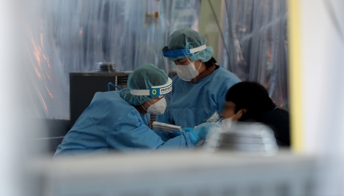 강추위가 이어진 23일 오전 서울 중구 서울광장 임시선별검사소에서 의료진이 코로나19 검사를 하고 있다.