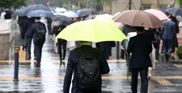 이슬비가 내리고 있는 지난해 5월17일 오전 서울 영등포구 여의도역 인근에서 시민들이 우산을 쓰고 걸어가고 있다.