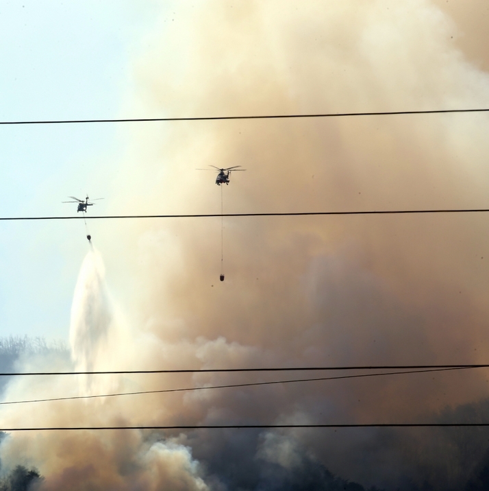 6일 오후 육군 헬기 조종사가 강원 강릉시 옥계면 남양2리 야산에서 발생한 산불 현장으로 안전하게 비행하며 물을 투하하고 있다.
