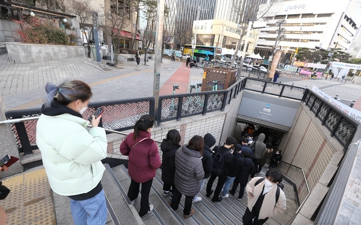 0시 기준 코로나19 신규 확진자가 21만716명 발생한 7일 오전 서울 송파구보건소 선별진료소를 찾은 시민들이 검사를 받기 위해 건너편 지하보도 출입구에서 대기하고 있다.