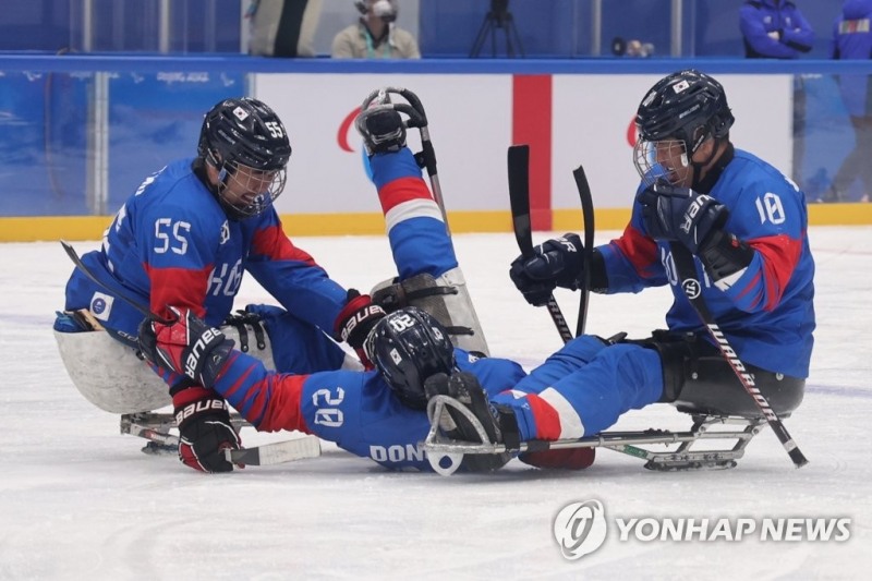 (베이징=연합뉴스) 9일 오후 중국 베이징 국립실내체육관에서 열린 2022 베이징 동계패럴림픽 장애인아이스하키 4강 진출 결정 플레이오프 한국 대 이탈리아 경기. 첫번째 골에 이어 팀의 네번째 골을 성공시킨 한국 장동신(가운데)이 선수들과 환호하고 있다.