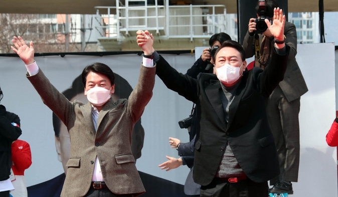 윤석열 국민의힘 대선후보가 투표를 하루 앞둔 8일 부산 연제구에서 열린 "국민이 승리합니다" 부산 거점 유세에서 윤 후보 지지를 선언한 뒤 후보직을 사퇴한 국민의당 안철수 대표와 지지자들의 환호에 손을 들어 인사하고 있다.