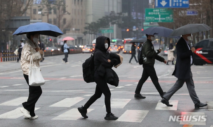 전국적으로 봄비가 내린 지난 14일 서울 중구 을지로에서 미처 우산을 준비하지 못한 시민들이 외투를 머리에 쓰고 걸어가고 있다.