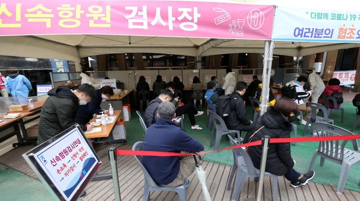 지난 18일 서울 송파구보건소 선별진료소에서 시민들이 신속항원 검사를 마친 뒤 결과를 기다리고 있다.