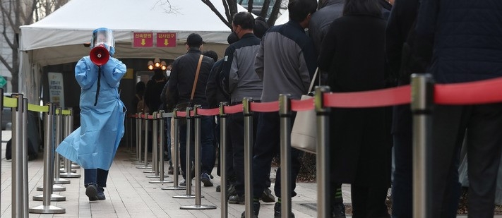 21일 오전 서울 중구 서울광장 임시선별검사소에서 의료진이 길게 줄 선 시민들에게 코로나19 검사 안내를 하고 있다.