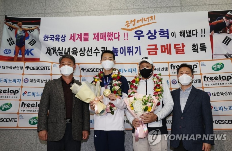 (영종도=연합뉴스) 세르비아 베오그라드에서 열린 2022 세계실내육상선수권대회 남자 높이뛰기 결선에서 2m34를 뛰어 우승한 '스마일 점퍼' 우상혁(왼쪽 두번째)이 22일 영종도 인천국제공항 제1여객터미널을 통해 귀국한 뒤 꽃목걸이를 걸고 기념촬영을 하고 있다.