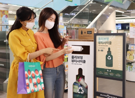 올리브영 명동 플래그십에서 고객이 뷰티사이클 캠페인에 참여하고 있는 모습