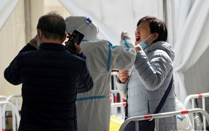 21일 중국 베이징의 한 코로나19 검사소에서 코로나19 검사를 받는 여성이 고통스러운 표정을 짓고 있다. 중국에서 오미크론 변이로 인한 코로나19 확산이 이어지자 상하이 디즈니랜드가 임시 폐쇄를 결정했다. 디즈니리조트 측은 "팬데믹 상황을 계속 주시하면서 당국과 협의할 것"이라며 "운영 재개 날짜를 확정하는 대로 알릴 것"이라고 전했다.